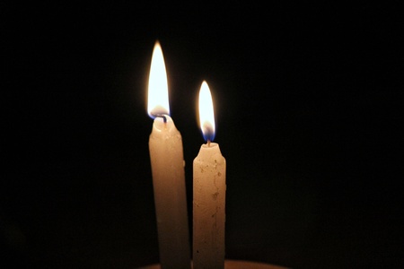 Two Candles in flames with black backgroundの写真素材