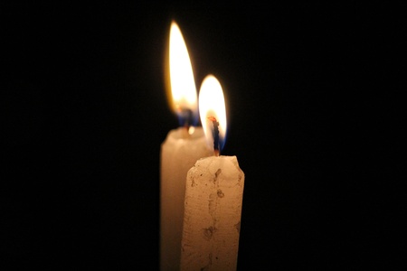 Two Candles in flames with black backgroundの写真素材
