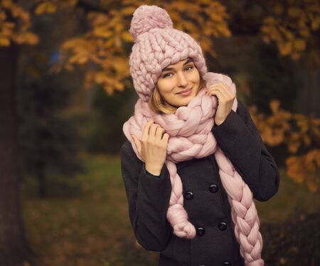Beautiful young woman wearing merino wool pastel colors hat and scarf enjoying the fresh morning outdoorsの写真素材