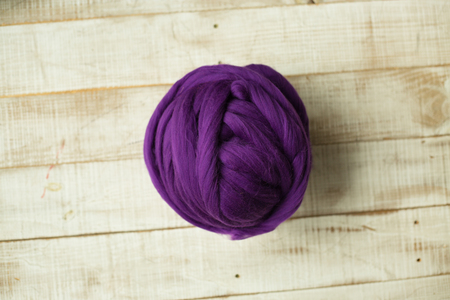 Purple merino wool ball on wooden backgroundの写真素材