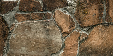 Cracked old stone wall background, grunge texture close up.