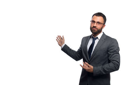 Businessman in glasses with a beard looks at the camera pointing with his hands to the side, a photograph of the waistの写真素材