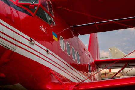 Part of the gleaming hull of a red UR ANC small passenger plane in sunset light. Exhibit of the National Museum of Aviation History. May 10, 2019 Kiev, Ukraineのeditorial素材