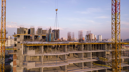 Workers on a high-rise building in the evening clog the formwork for pouring concrete.