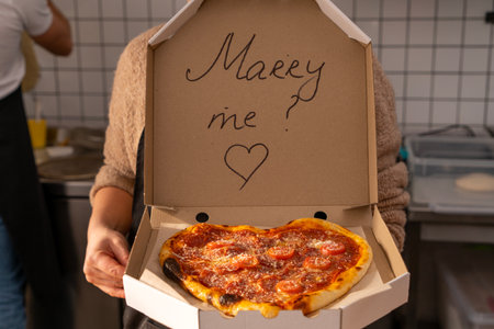 A romantic proposal of love with delicious pizza and the inscription on the box of Merry Meの写真素材