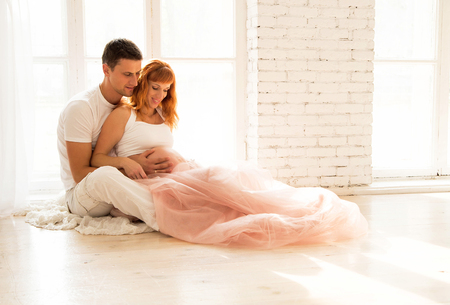 pregnant woman in a tulle skirt and her husbandの写真素材