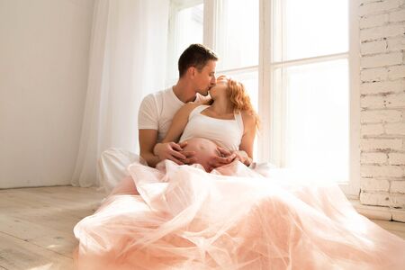 pregnant woman in a tulle skirt and her husbandの写真素材