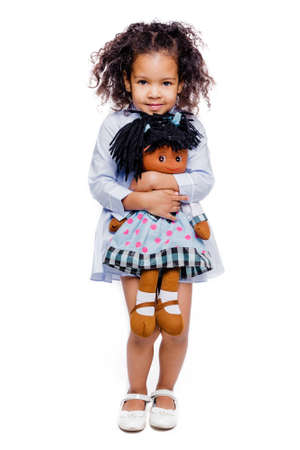 Portrait of a pretty little african american girl in a blue dress with a bow around her neck. Horizontal photoの写真素材