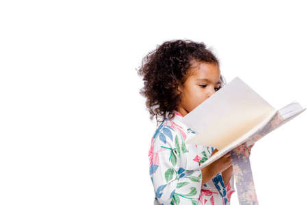 Little pretty fashionable african american girl in white floral dress looking at notebook. Horizontal photoの写真素材