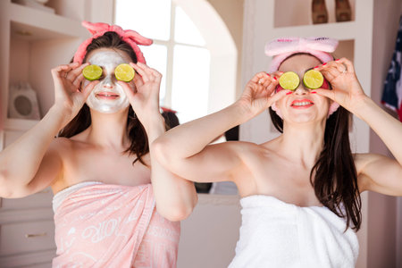 Beautiful, happy, positive women wrapped in a towel, a cosmetic bandage on their heads and with...