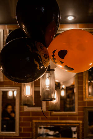 Electric lamps and balloons as Halloween decor in a cafe. Vertical photoの写真素材