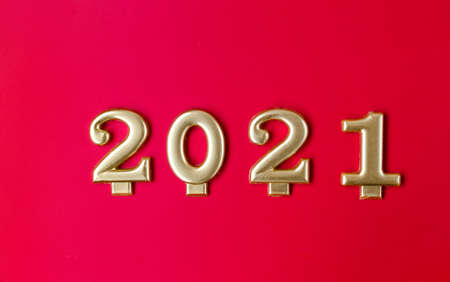 Happy New year 2021 celebration. Golden numbers 2021 as a symbol of the coming year on a red background. Horizontal photoの写真素材