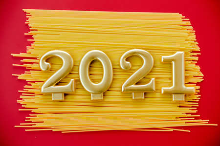 Happy New Year 2021. Symbol from number 2021 and macaroni on red background. Horizontal photoの写真素材