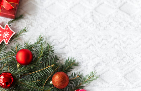 New year frame mockup. Pine cones, fir branches and Christmas balls on white knit background. Flat...