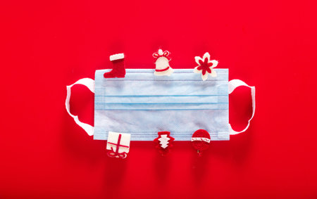 Medical protective mask with decorative wooden clothespins on a red background. Protection from coronavirus. Horizontal photoの写真素材
