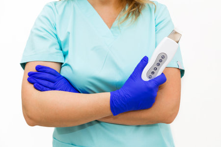 Close-up of a beautician in blue suit holding an ultrasound apparatus. isolated on white background.