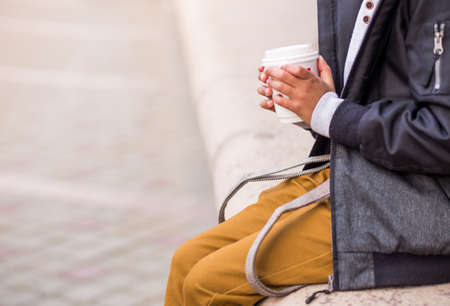 little african american boy pose on a city street in autumn clothes with cup of hot chocolate in hands. Photoの写真素材
