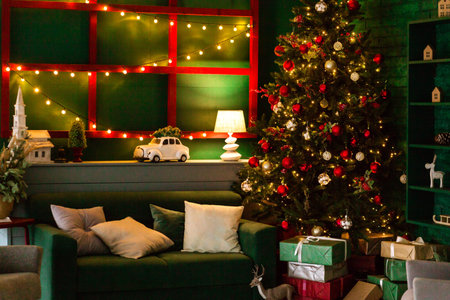 Evening New Year interior of the room. Cozy light from the lamp illuminates the green sofa and the Christmas tree. Photoの写真素材