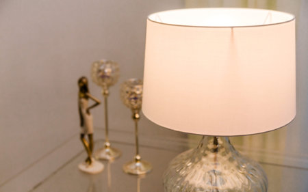 There is a lamp and decor on the table. Photoの写真素材