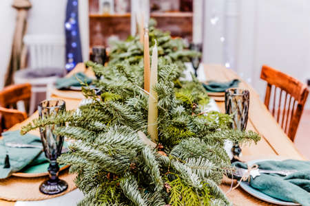 Table setting with candles and new year tree branches. Photoの写真素材