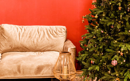 Velvet sofa and christmas tree stand against red wall background