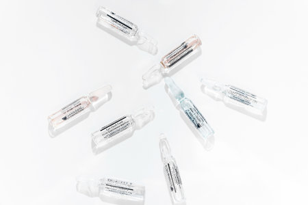 Glass beauty ampoule with concentrated essence inside on white background- Minsk, Belarus- August 20, 2021. Horizontal photoのeditorial素材