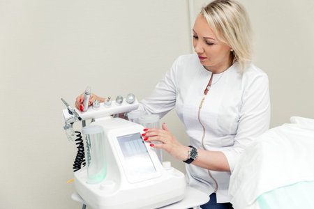 Woman dermatologist posing in her office with a beauty machine. Horizontal photo