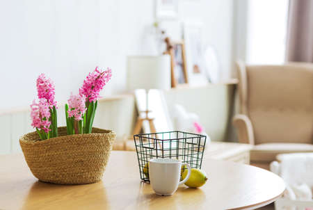 A vase with hyacinth, lemons in a metal vase and a cup are on the table. The concept of home comfort and a bright calm morningの写真素材