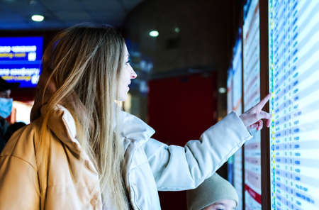Young woman stands near the information boardの写真素材