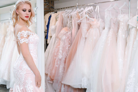 Beautiful blonde girl trying on a wedding dress in a wedding dress salonの写真素材