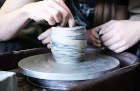 Male and female hands make a vase of clay. Date in the workshop. Horizontal photoの写真素材
