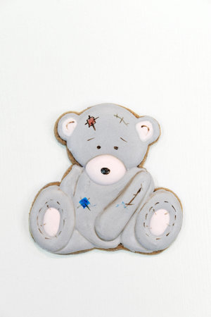 Gingerbread in the shape of a gray teddy bear on a white background. Top viewの写真素材