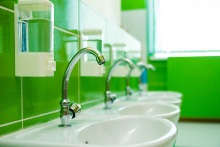 Children toilet in kindergarten or school. toilet in kindergarten bathroom in public area. inside bathroom of nursery school with white sinks and dispenser. Horizontal photo. Minsk, Belarus- April 10, 2022の写真素材