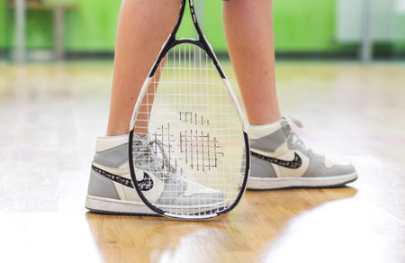 Boy teenager in sports shoes and with a racket posing in a squash room. Horizontal photo. Minsk, Belarus- May 25, 2022のeditorial素材