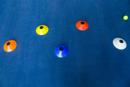 Colorful plastic cones on a blue cement tennis court. Top view. Horizontal photo