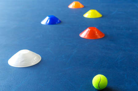 Colorful plastic cones on a blue cement tennis court. Horizontal photoの写真素材