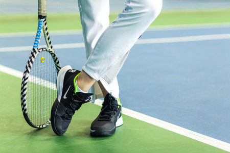 Woman in white sports uniform with tennis racket posing for the camera. Horizontal photo. Minsk, Belarus- May 25, 2022のeditorial素材