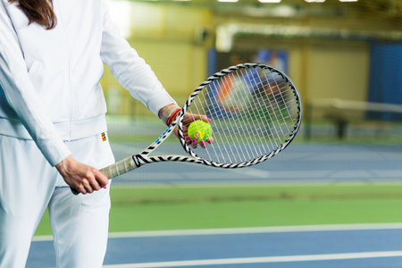 A woman in a white sports uniform with a tennis racket poses for the camera. Horizontal photo. Minsk, Belarus- May 25, 2022のeditorial素材
