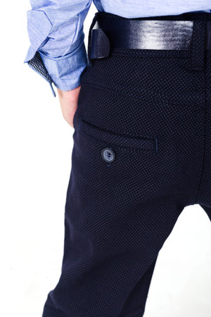 Boy schoolboy in trousers and shirt on a white background. The boy demonstrates the presence of...