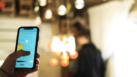 A man uses an application on his phone to change the color of electrical devices in the interior....