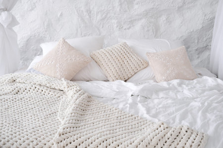 Cozy and fashion place for rest with pillow and knitted plaid. Horizontal photo
