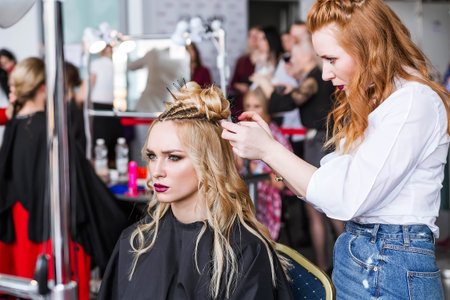 Competition stylists hairdressers at the exhibition of hairstyles and makeup. Hairdresser creates...