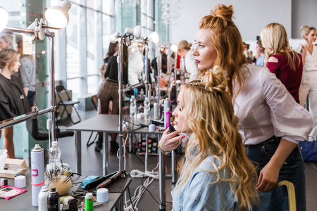 Competition stylists hairdressers at the exhibition of hairstyles and makeup. Hairdressers create hairstyles for their models. Horizontal photoの写真素材