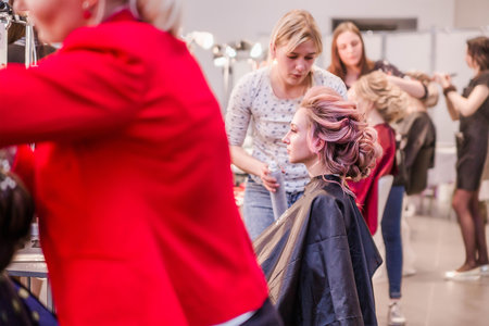 Competition among bridal hair stylists. The hairdresser makes a wedding hairstyle. Minsk, Belarus - April 10, 2022. Horizontal photoのeditorial素材