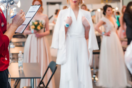 Competition of wedding stylists. The jury of the competition evaluates the hairstyles of the models. Horizontal photoの写真素材