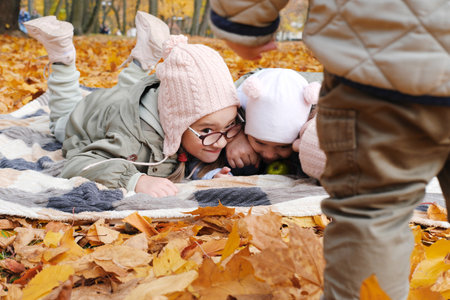 Children from a large family, four happy children have fun in the park. Girls hiding from their little brother. Horizontal photoの写真素材