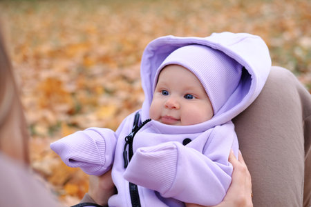 Young mother on a walk with a baby in the autumn park. Close-up of a child's face. Horizontal photoの写真素材