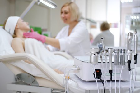 Woman receiving a cosmetic facial treatment from a specialist in a modern medical clinic with professional equipmentの写真素材