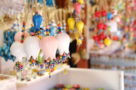 Hanging ceramic tulip-shaped ornaments and evil eye beads showcased in a local Mediterranean market.の写真素材