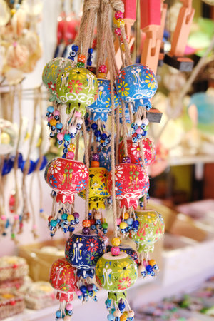 A display of colorful Turkish ceramic bell ornaments adorned with evil eye beads at a local market.の写真素材